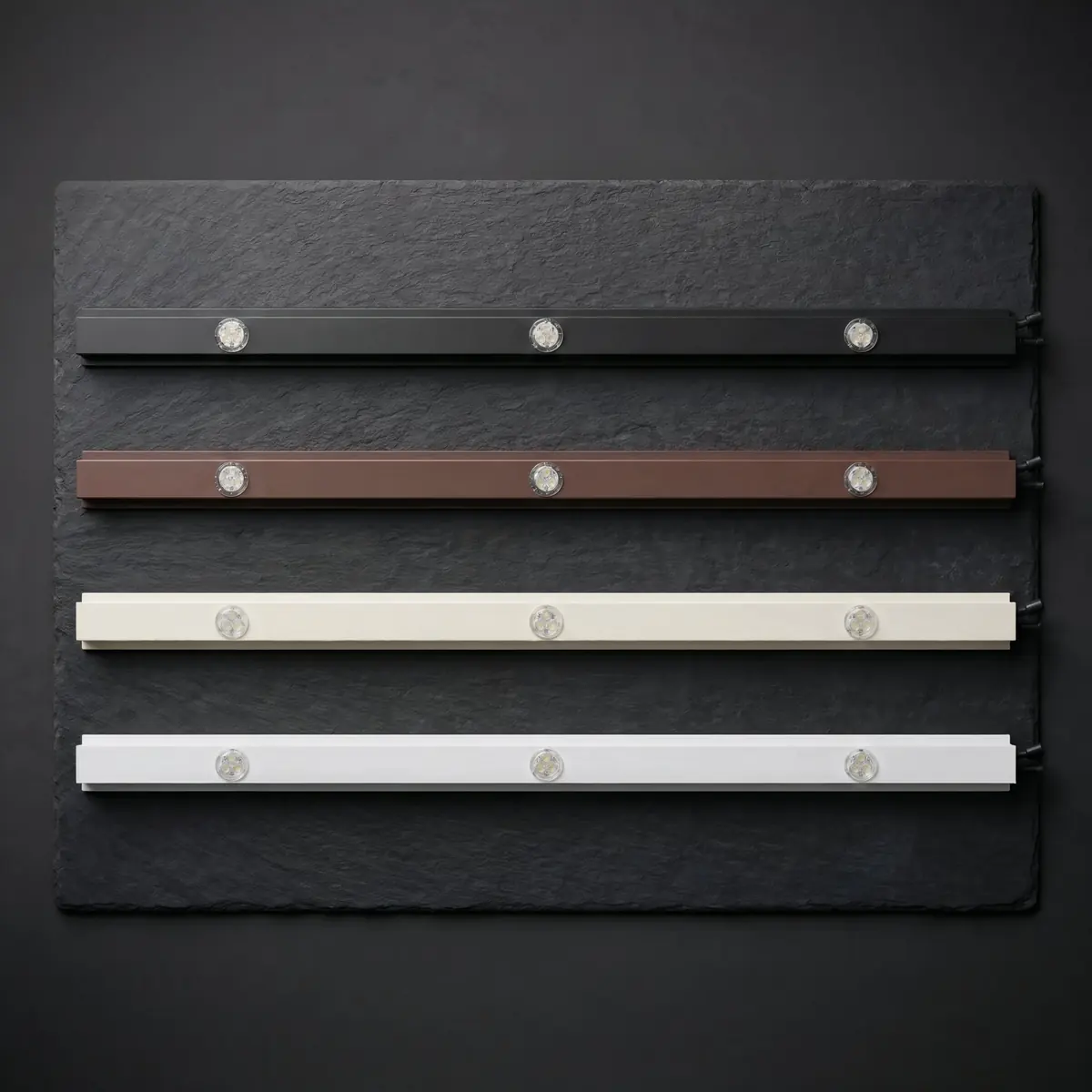 Close-up of RGBW pucks in matte black IronPeak track, lit red, green, blue, and amber
